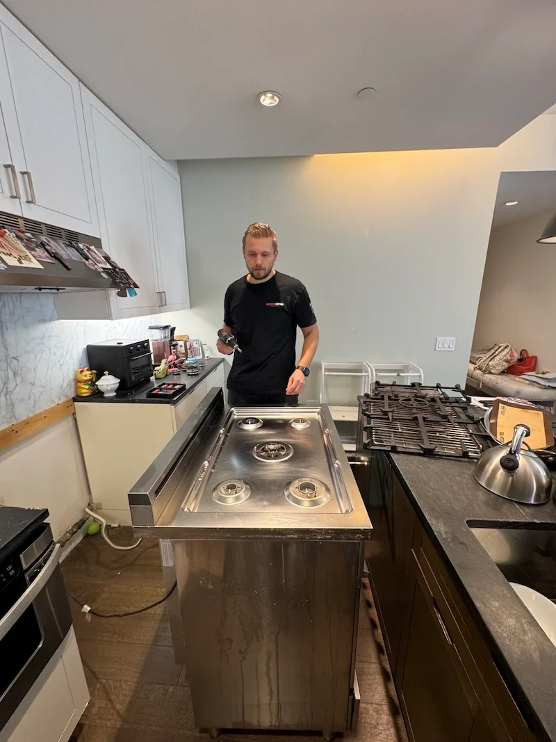 Elevate Repair technician servicing an appliance in a NYC home